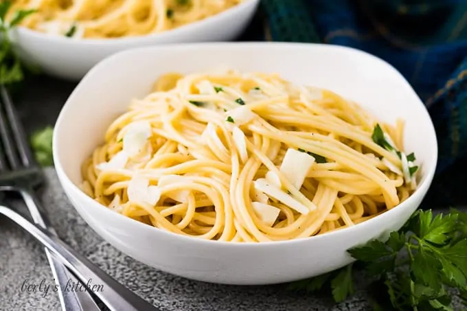 A decorative bowl of garlic butter sauce tossed with pasta.