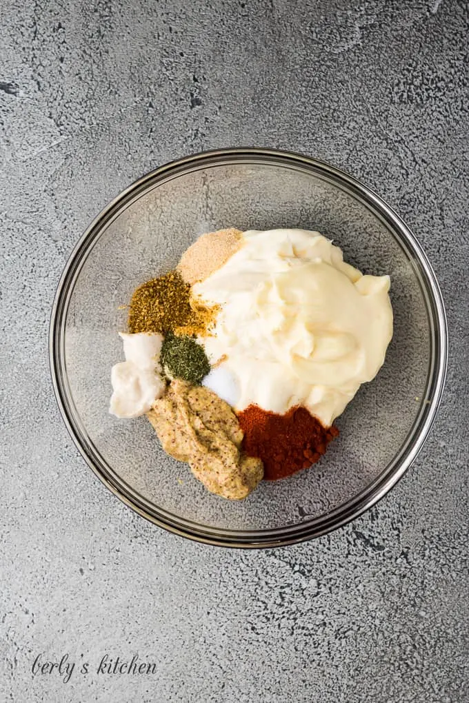 The mayo, spices, and other ingredients in a mixing bowl.