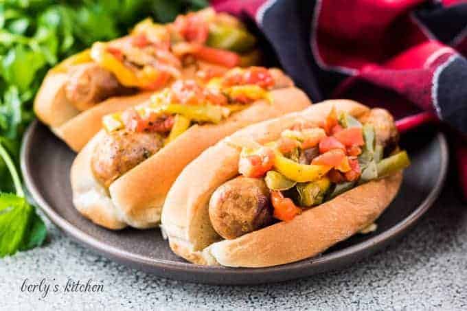 Three servings of instant pot sausage and peppers in buns.
