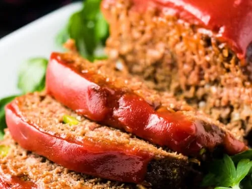 The meatloaf has been sliced and placed on a serving platter.