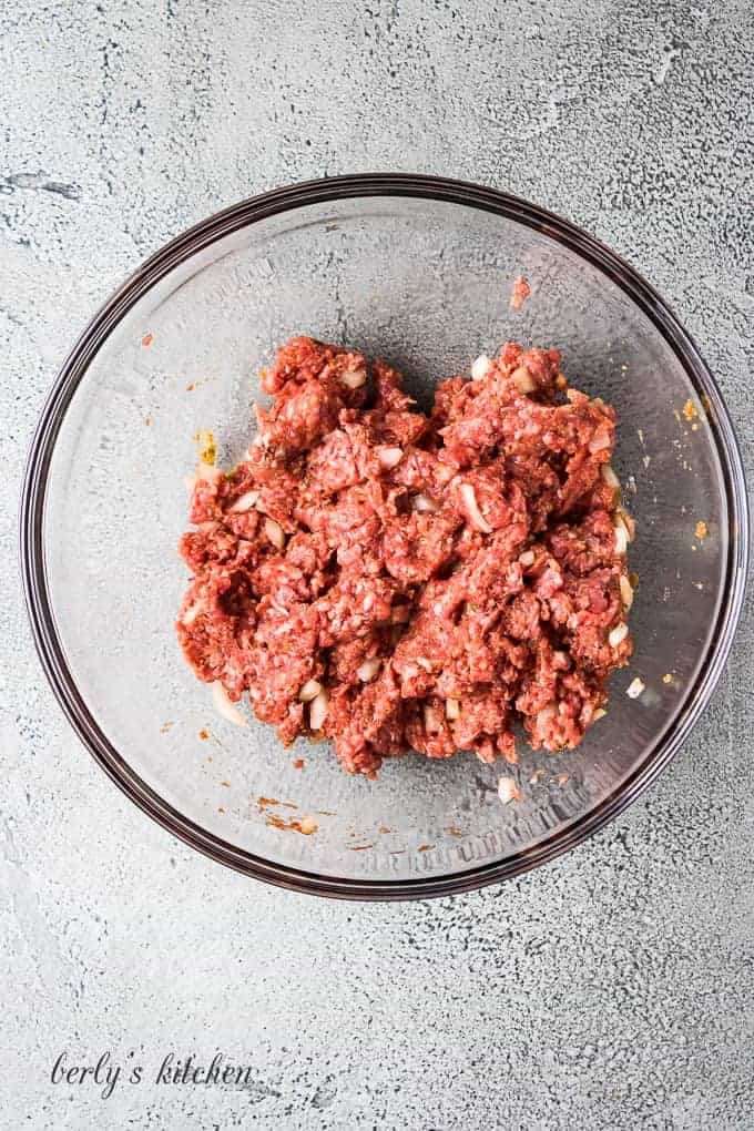 The ground beef has been combined with the other ingredients.