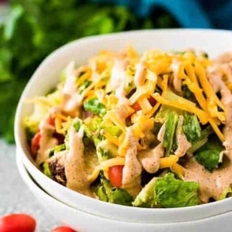 A bowl filled with Southwest chicken salad topped with dressing.
