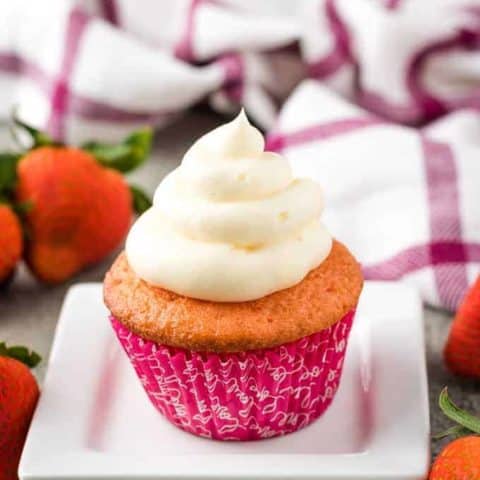 A single cupcake on a decorative plate topped with frosting.