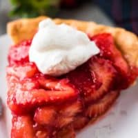 A large slice of pie showing all the fresh strawberries.