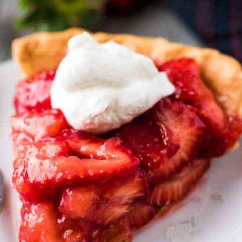 A large slice of pie showing all the fresh strawberries.