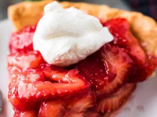 A large slice of pie showing all the fresh strawberries.