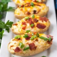 The potatoes topped with cheese, bacon, and sliced green onions.