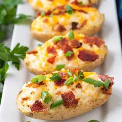Twice Baked Potatoes Recipe The potatoes topped with cheese, bacon, and sliced green onions.