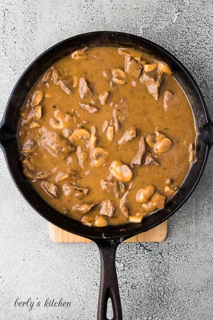 The gravy and meat in a large cast iron skillet.