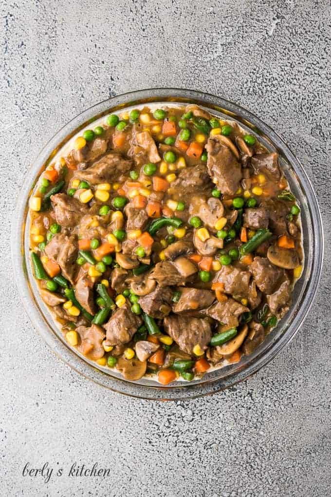 The beef pot pie filling transferred to a pie pan.