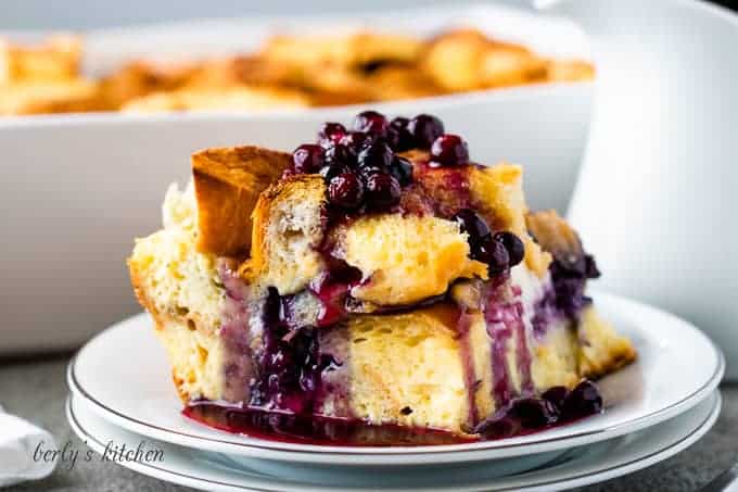 A piece of the french toast casserole drizzled with blueberry sauce.