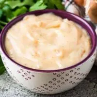 The cream of onion soup in a decorative purple bowl.