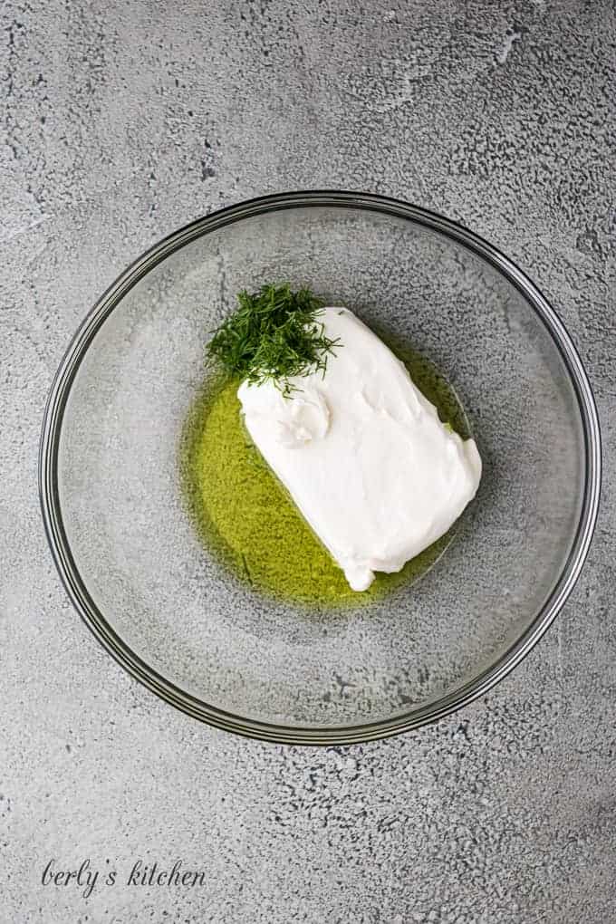 Cream cheese, pickle juice, and fresh dill in a bowl.