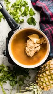Pineapple juice, brown sugar, and Dijon mustard cooking in a pan.