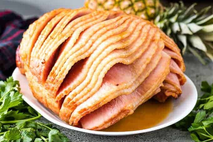 Spiral cut ham with a brown sugar glaze on a platter.