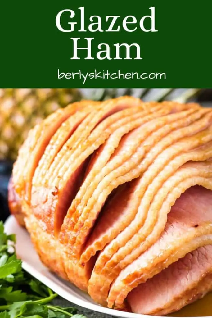 The glazed ham on a platter with parsley.