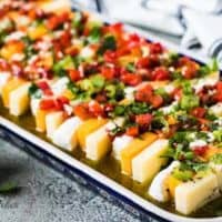 The finished marinated cheese served on a colorful rectangular plate.