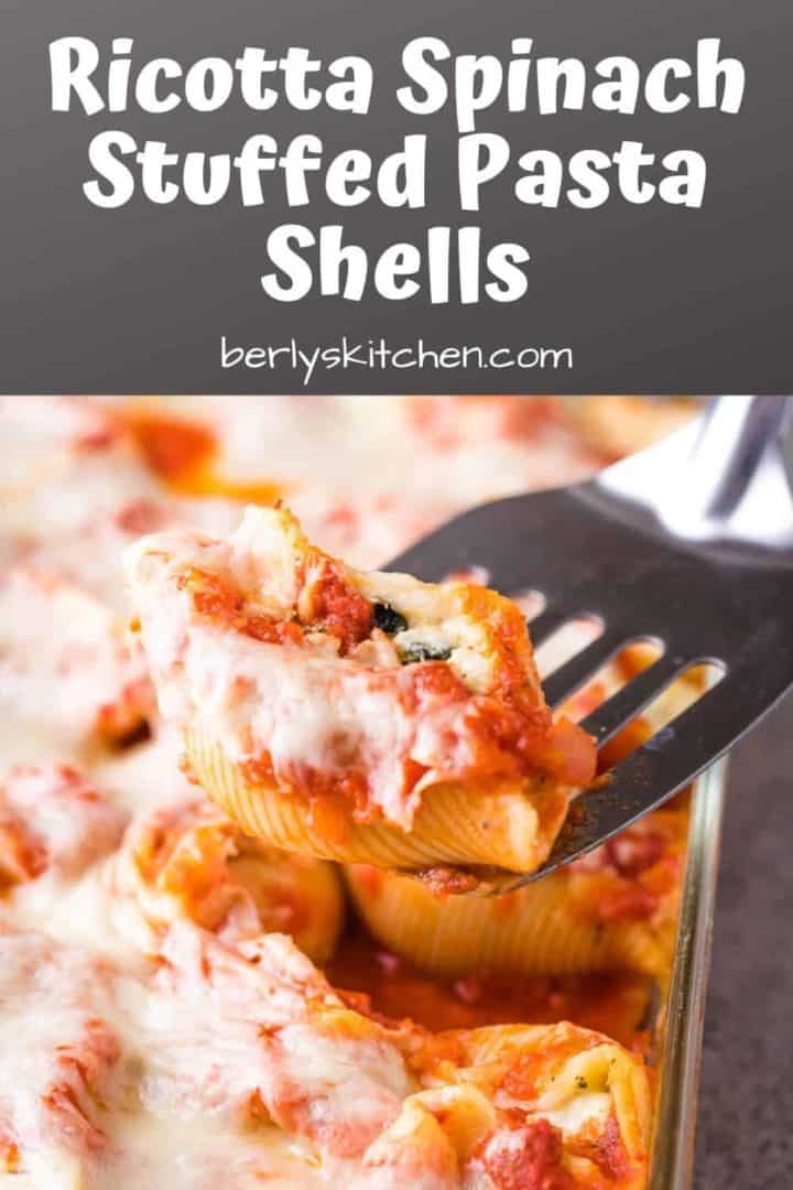 A ricotta spinach stuffed pasta shell being lifted from the pan.