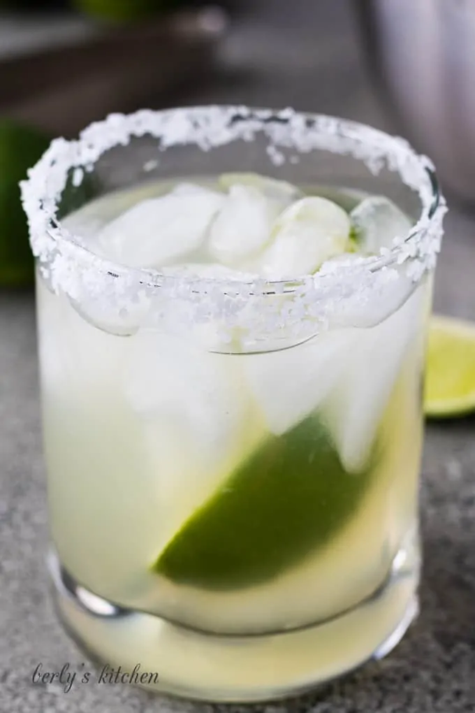 Simple margarita recipe on the rocks with a fresh lime wedge.