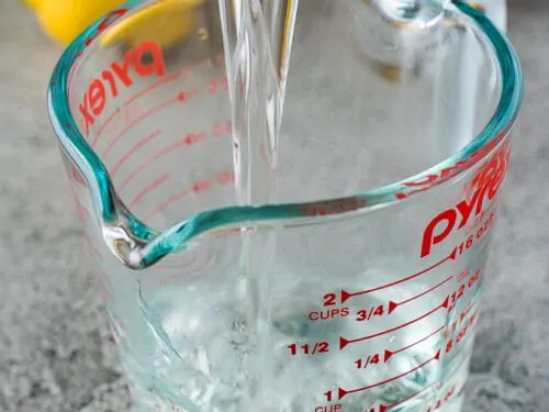 The finished syrup mixture pouring into a glass measuring cup.