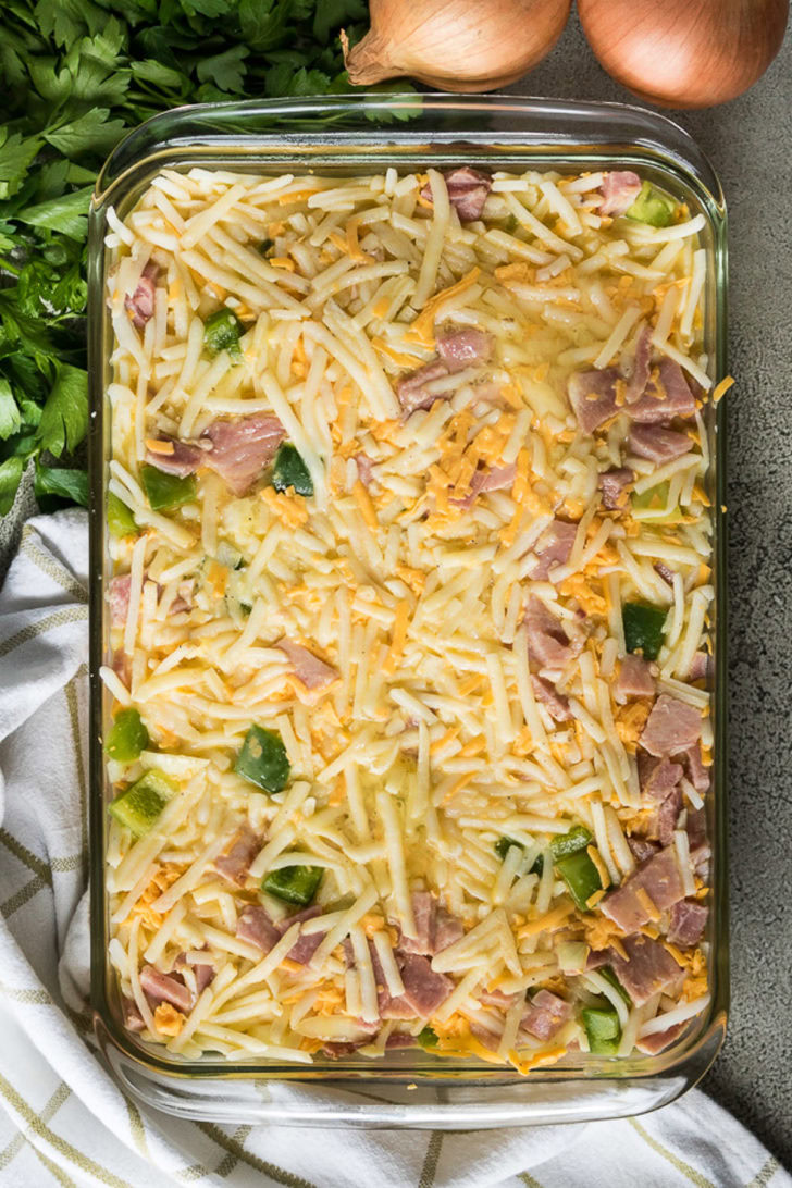The hash browns mixture and eggs combined in a baking dish.