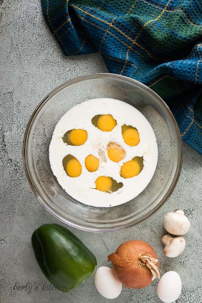 Cracked eggs, milk, and spices in a mixing bowl.