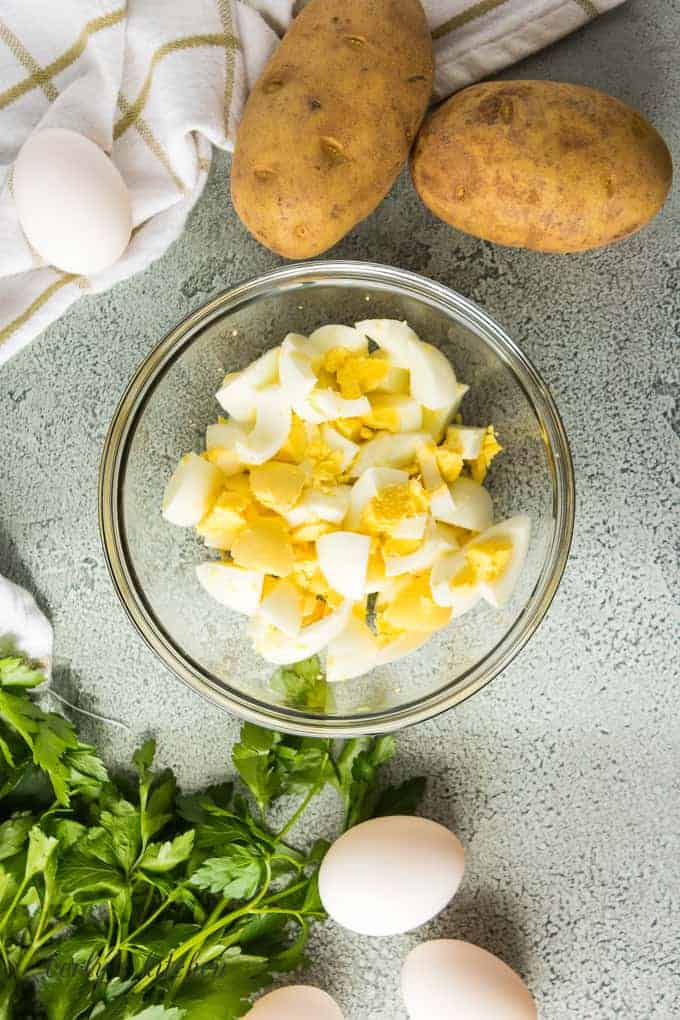 Ariel view of a bowl of boiled eggs chopped into bite sized pieces.