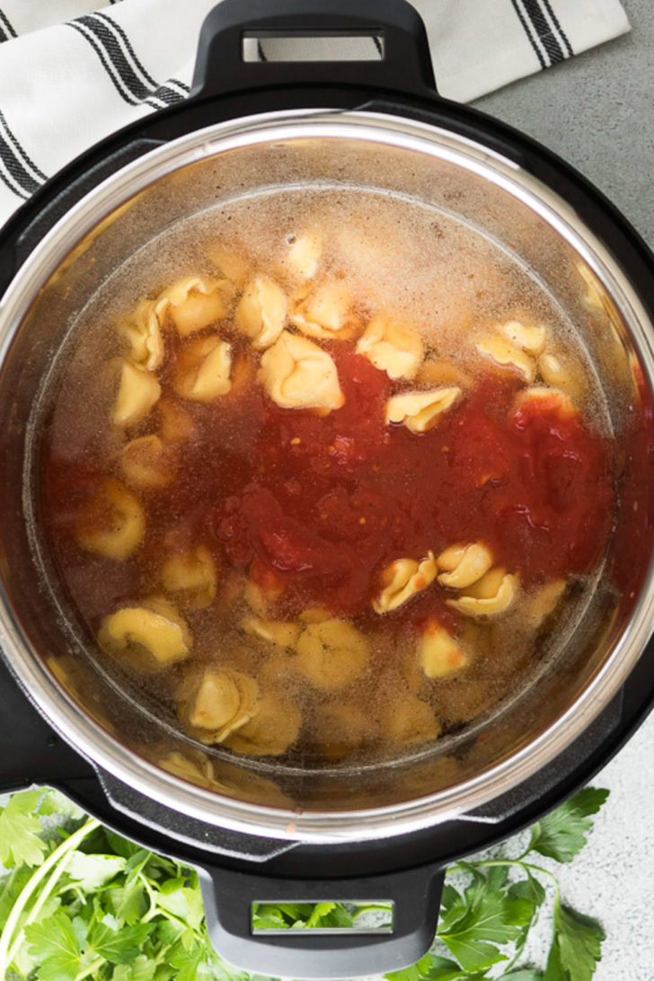 Canned tomatoes and tortellinis added to the broth.