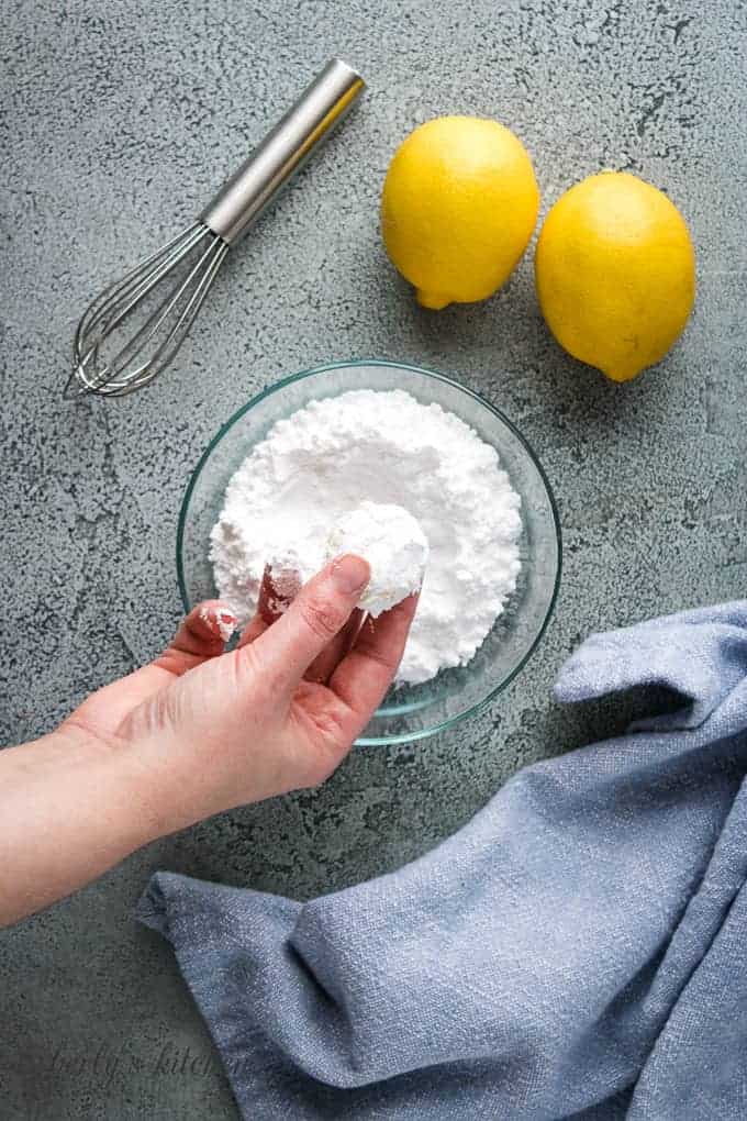 A ball of lemon cookie dough dipped into powdered sugar.