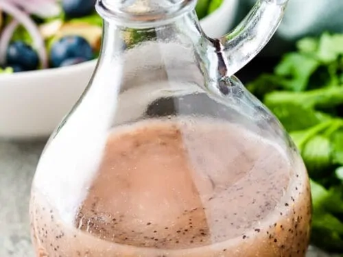 The finished salad dressing with a bowl of salad.