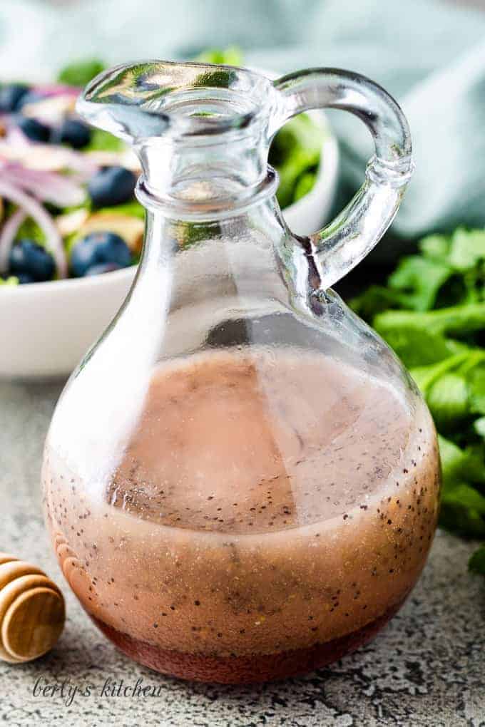 The finished salad dressing with a bowl of salad.