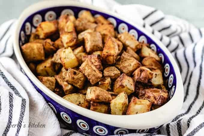 The seasoned air fryer home fries in an oval bowl.