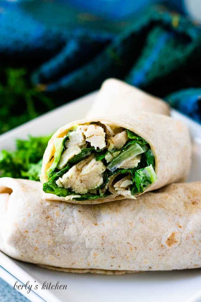 Two finished Caesar wraps on a plate.