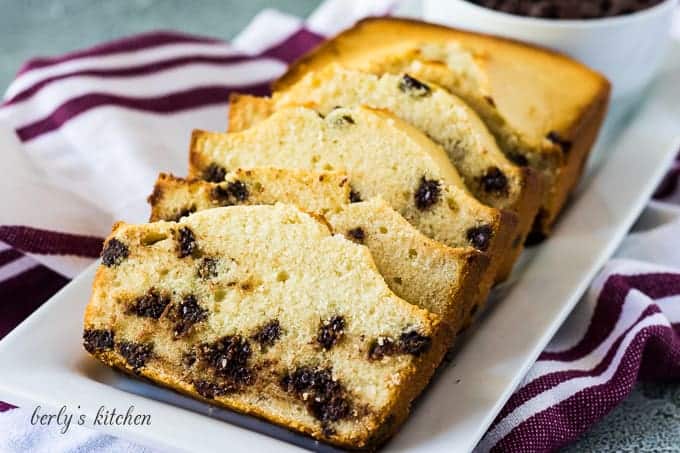 Four slices of chocolate chip loaf cake on a platter.