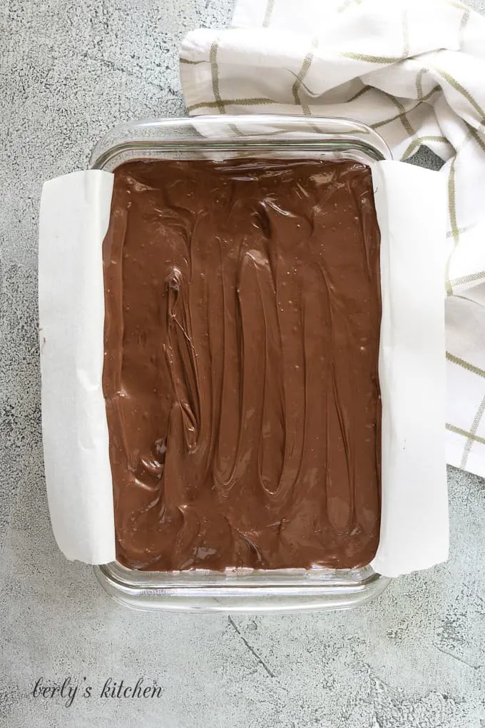 The chocolate topping has been poured over the filling.