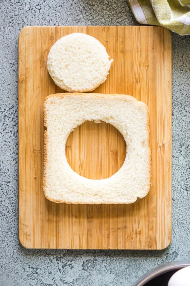 A piece of bread with circular hole cut in the middle.