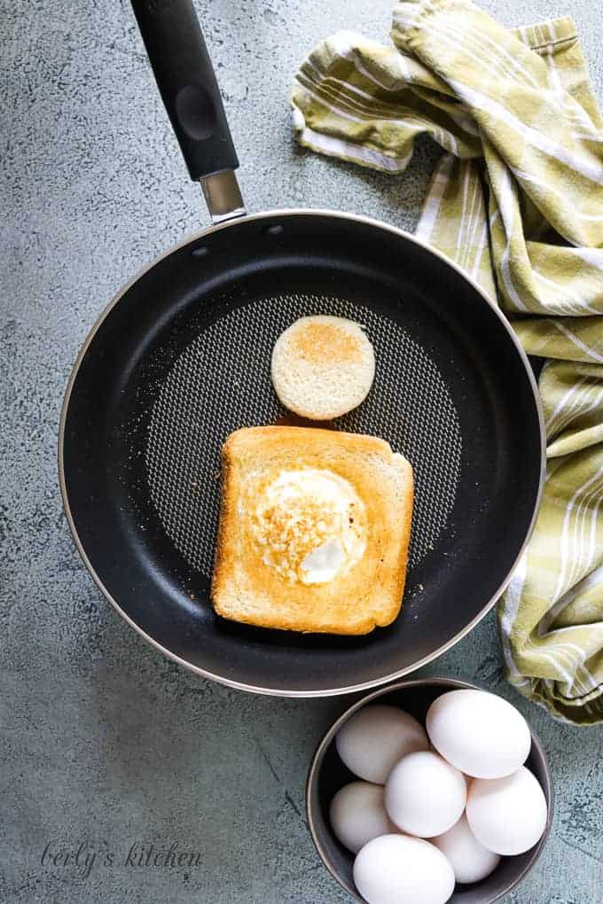 The egg in a toast basket flipped in the pan.