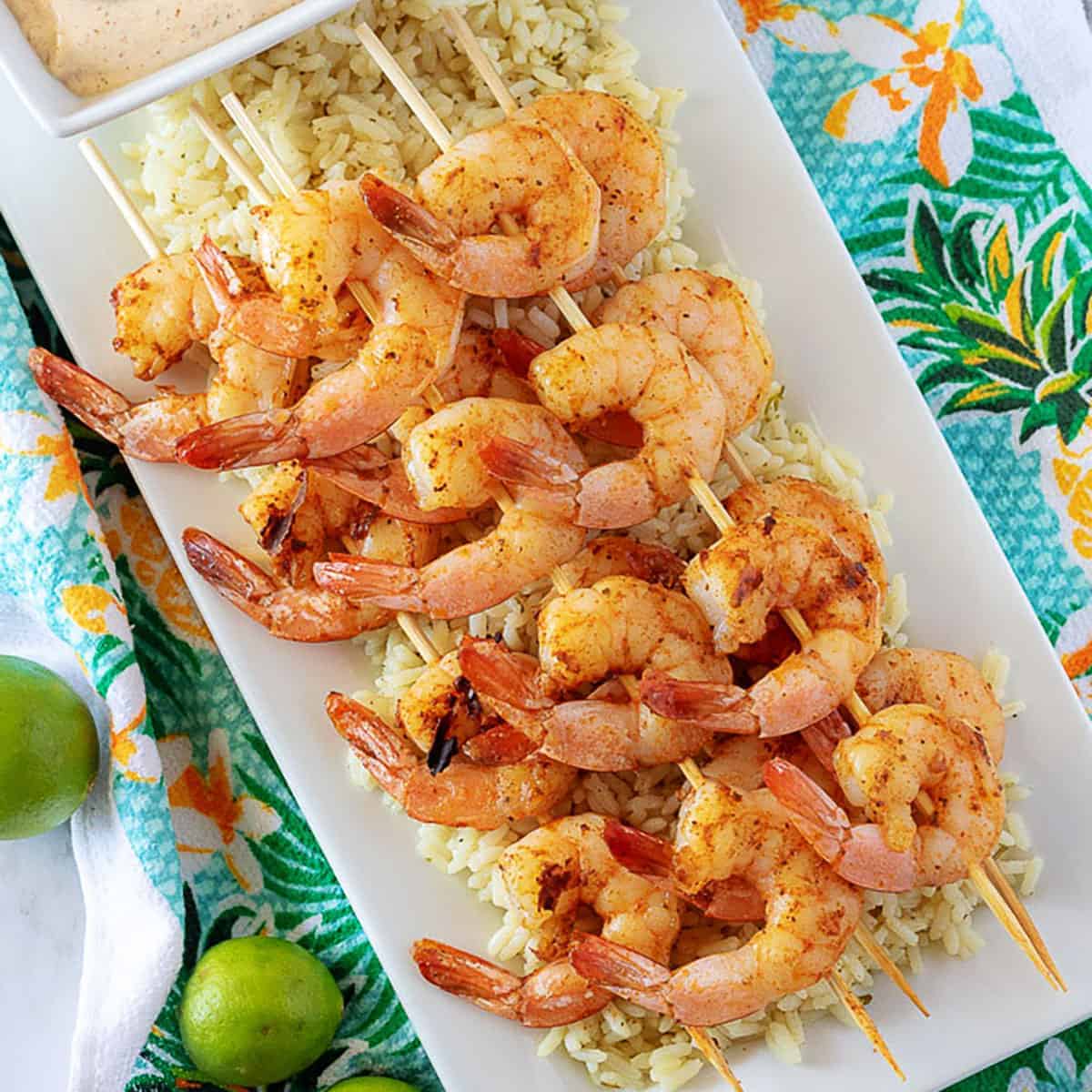 Top down view of grilled shrimp skewers on a bed of rice.