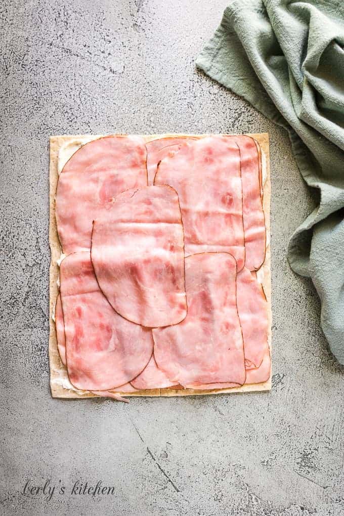 A layer of deli sliced ham has been placed over the filling.