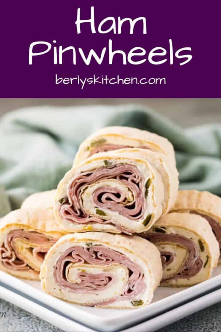 Multiple ham pinwheels stack on a square plate.