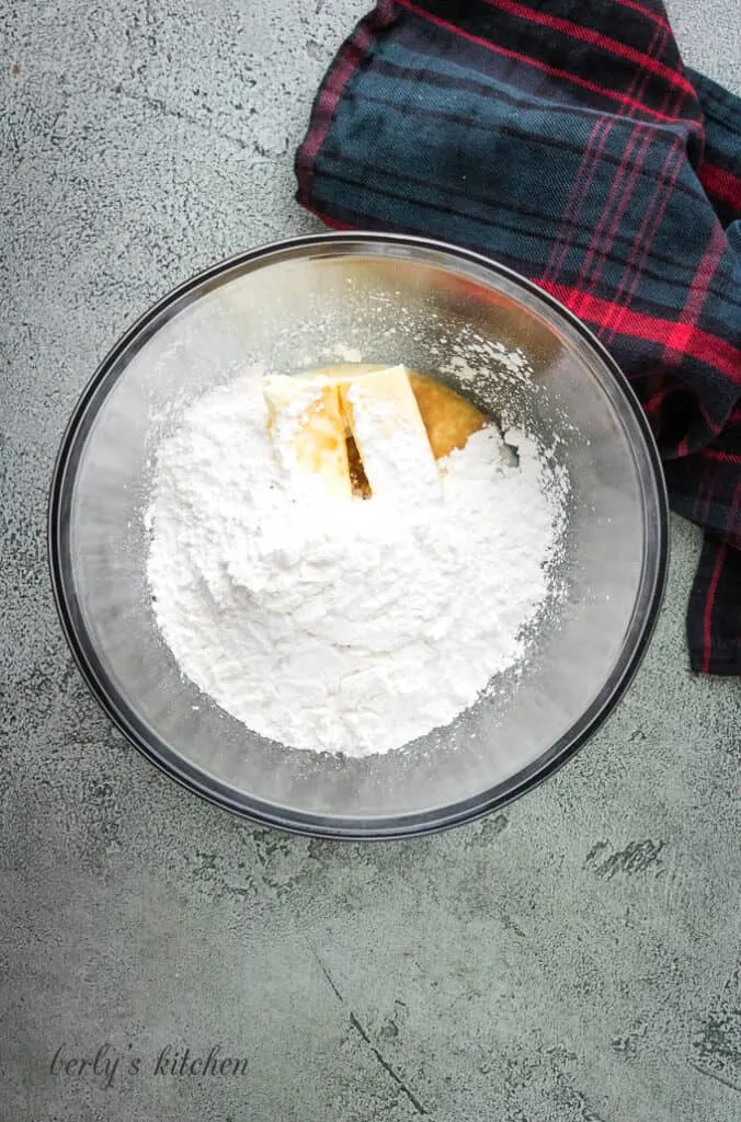 Butter, powdered sugar, and vanilla extract in a mixing bowl.
