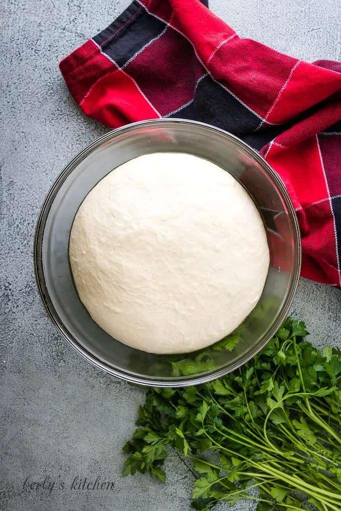 The pizza dough has rested and doubled in size.
