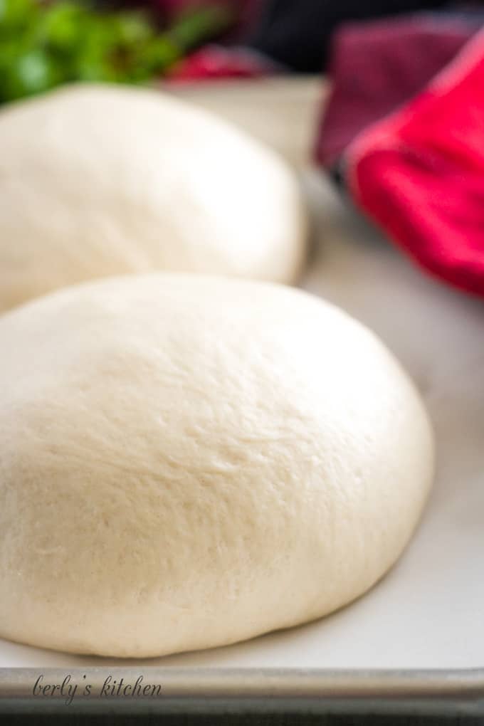 Copycat Publix pizza dough has been separated into 2 big balls.