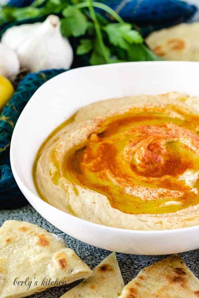 A finished creamy garlic hummus with flatbread.