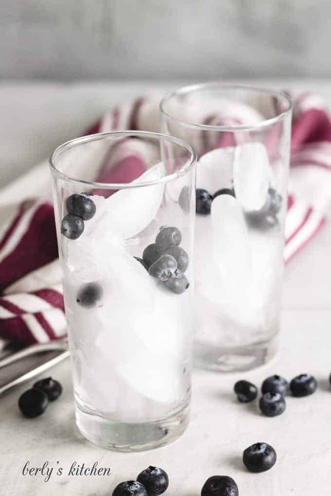 The glasses have been filled with ice and berries.