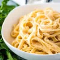 White bowl filled with spicy fettuccine Alfredo.