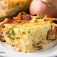Cheesy breakfast casserole on a white dish.