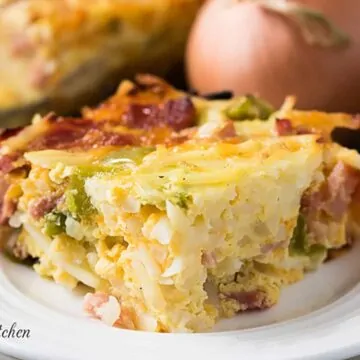 Cheesy breakfast casserole on a white dish.