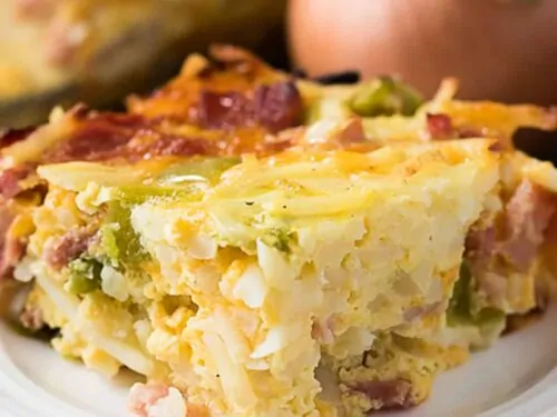Cheesy breakfast casserole on a white dish.