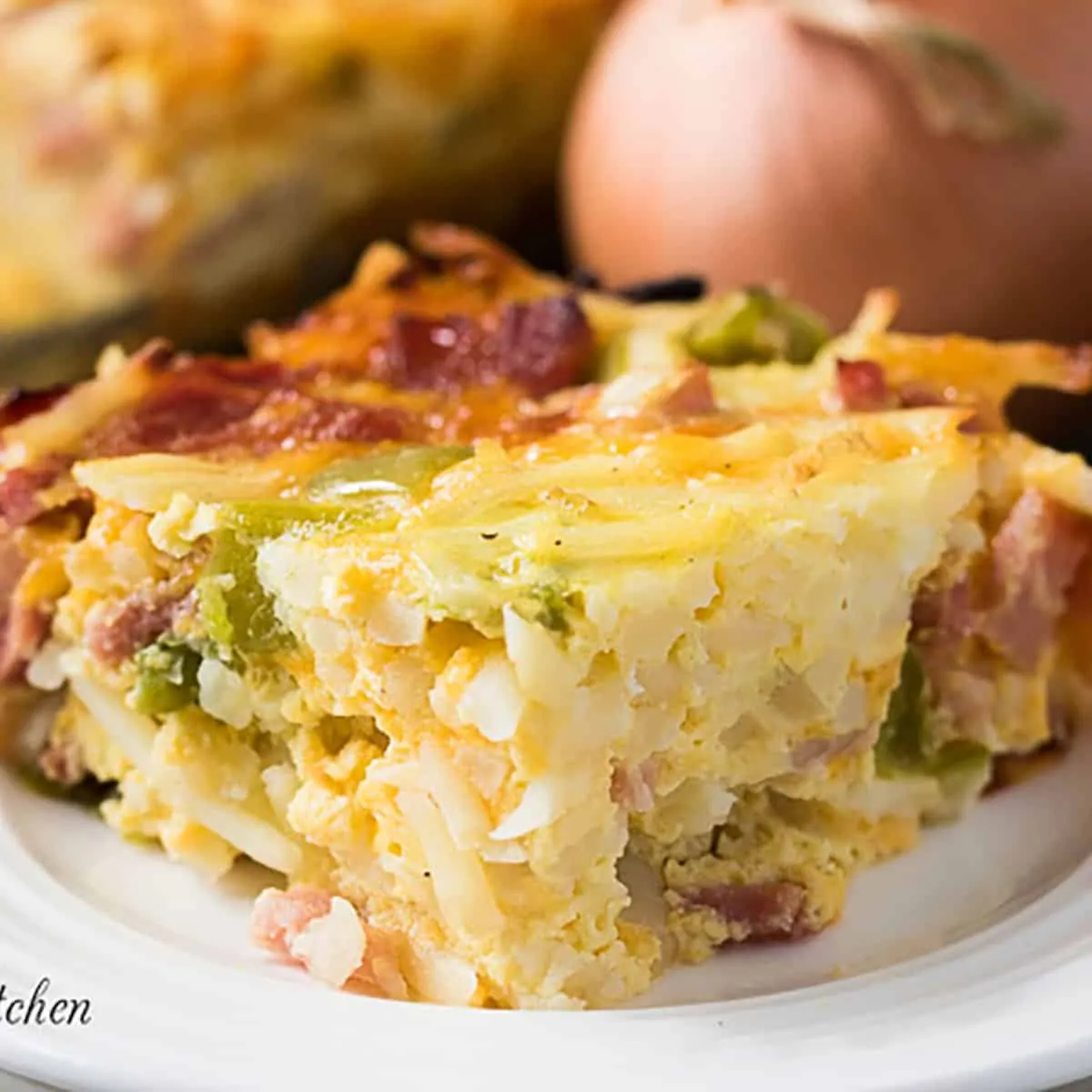 Cheesy breakfast casserole on a white dish.